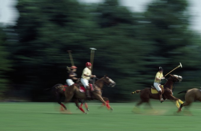 Side profile of three people playing polo